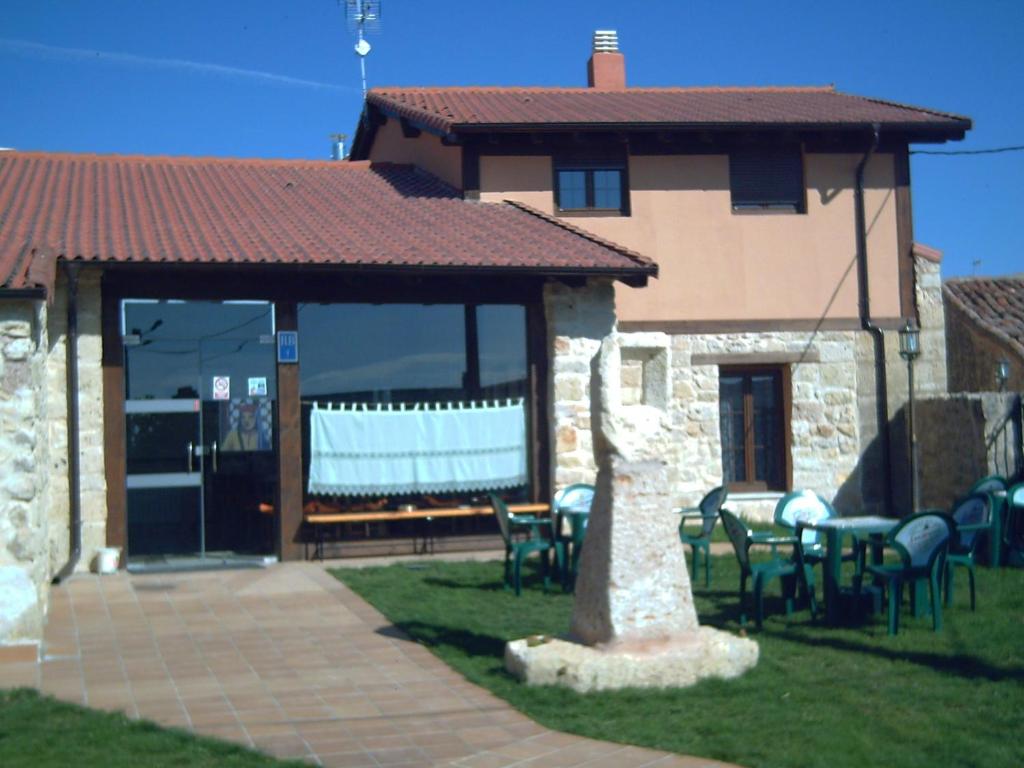 Cette maison dispose d'une terrasse avec des chaises et une table. dans l'établissement La Cerca de Doña Jimena, à Modúbar de San Cibrián