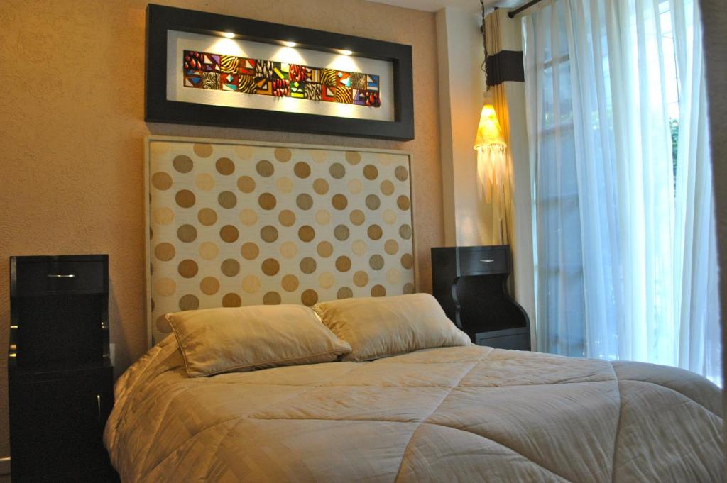 a bedroom with a bed and a stained glass window at Business Suites SG in Mexico City