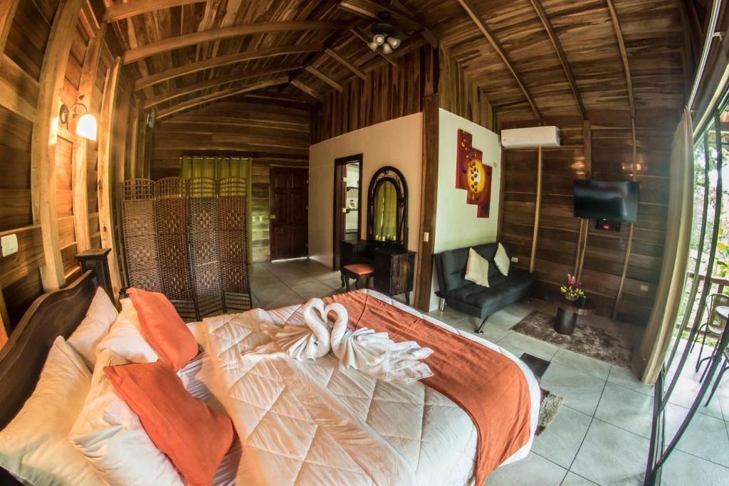 a bed room with a bed and a table at Hotel Rancho Cerro Azul in Fortuna