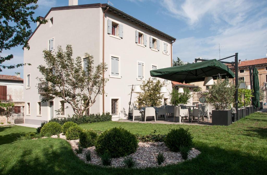 a large white building with a garden in front of it at Damaranto Residenza e Cucina in Soave