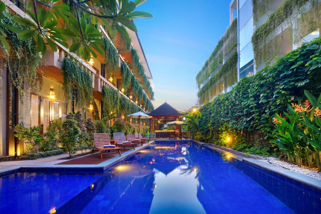 a swimming pool in the middle of a building at Bali Chaya Hotel Legian in Legian