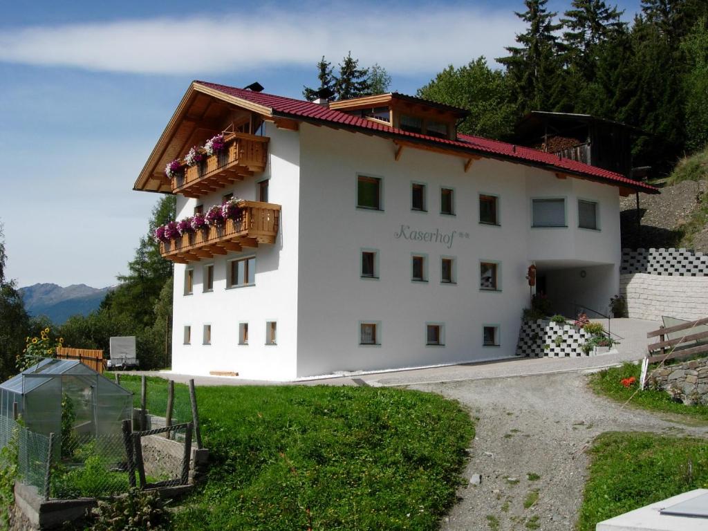 a white house with a balcony on a hill at Kaserhof in Bressanone