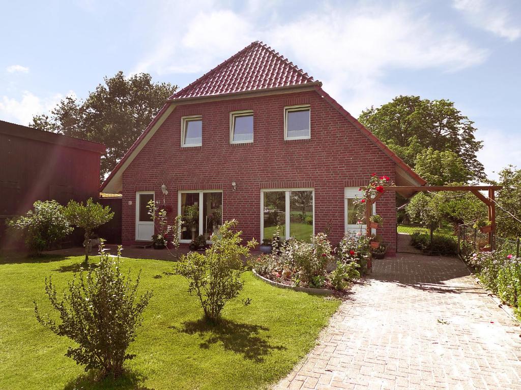 une maison en briques rouges avec un jardin en face de celle-ci dans l'établissement Apartment Villa Sorgenfrei by Interhome, à Ovelgönne