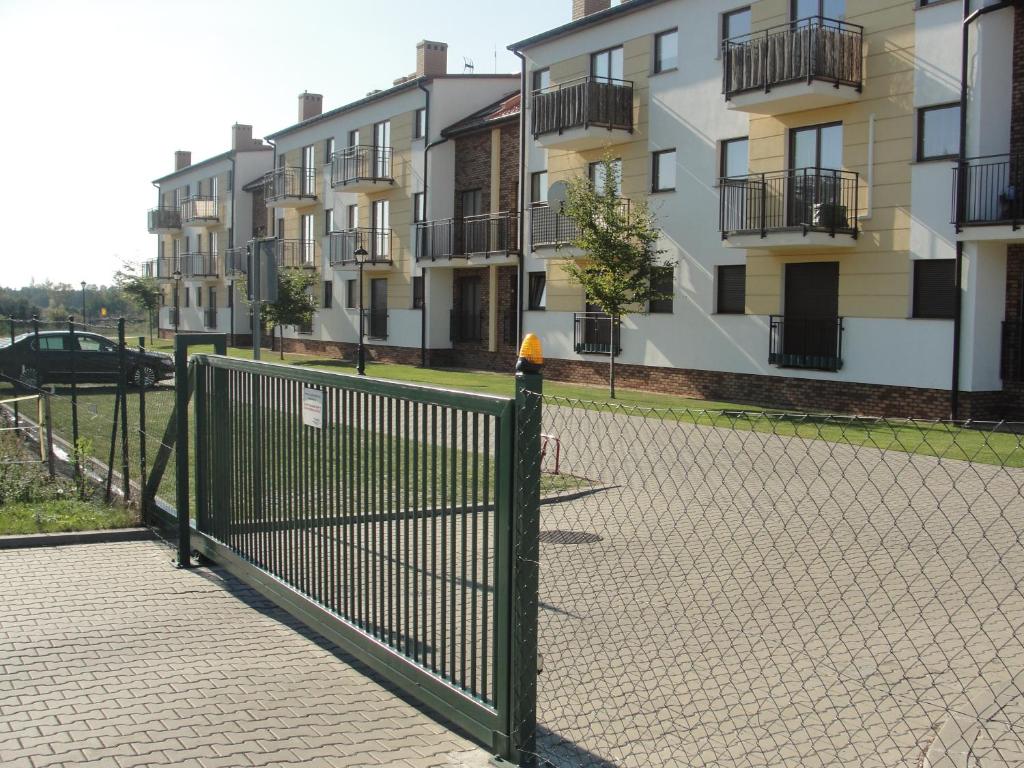 a fence in front of a row of buildings at Apartament Posejdon in Sztutowo