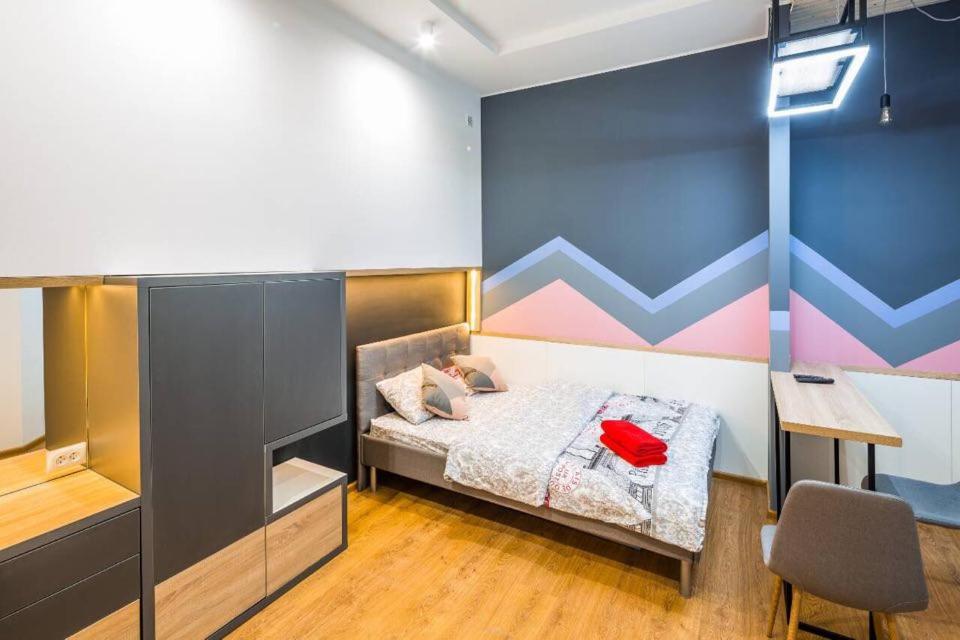 1 dormitorio con cama, escritorio y silla en Studio Loft, en Leópolis