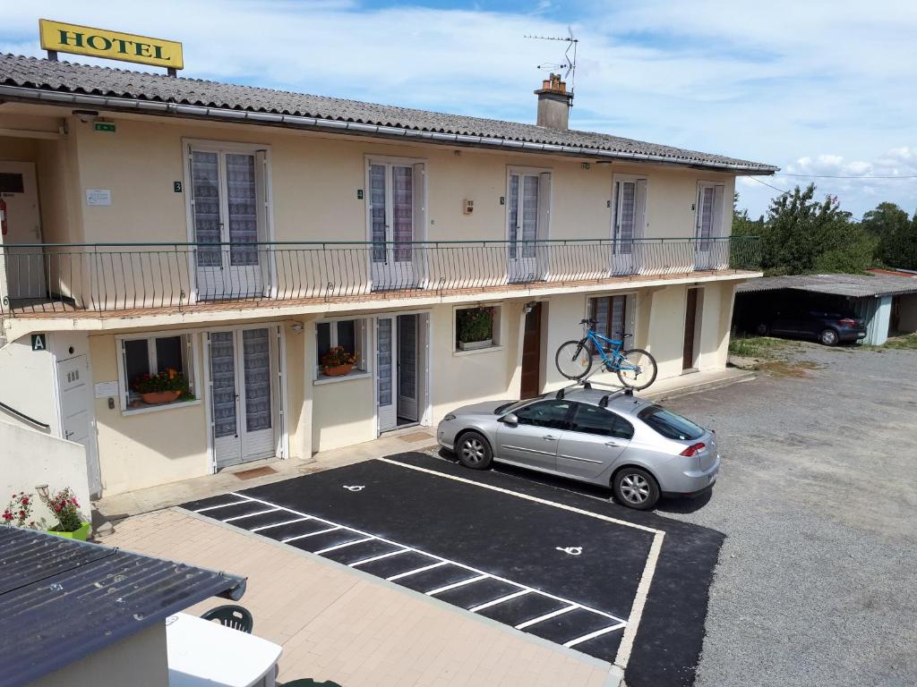 a car parked in a parking lot in front of a hotel at H&ocirc;tel Le Lithana in Pontorson