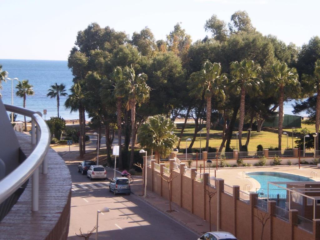 a view of a street with palm trees and the ocean at Apartamento 1ª línea de playa in Oropesa del Mar