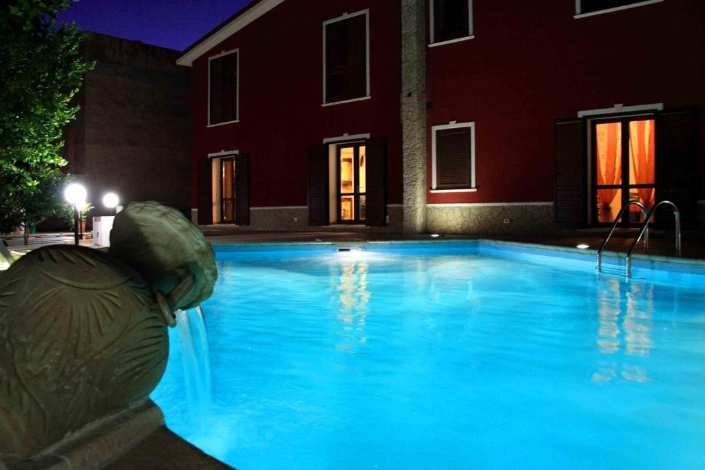 a swimming pool with a statue in front of a building at Il Quadrifoglio in Trapani