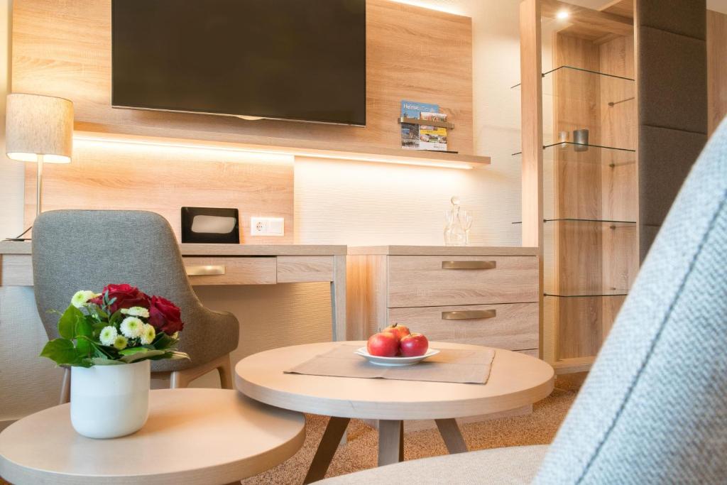 ein Zimmer mit einem Stuhl und einem Tisch mit einer Obstschale in der Unterkunft Hotel Altes Zollhaus in Horumersiel