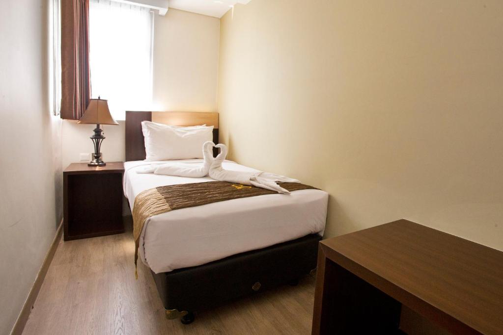 Postel nebo postele na pokoji v ubytování Hotel Gunawangsa MERR