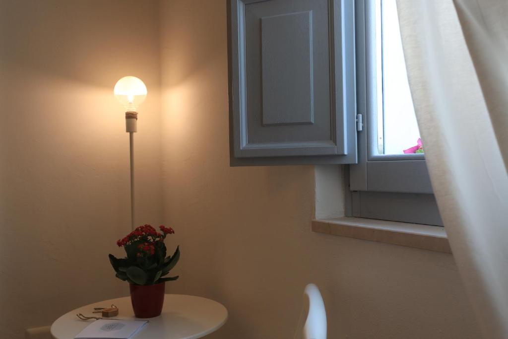 a bathroom with a toilet with a light and a window at FONTEblu B&B in Polignano a Mare