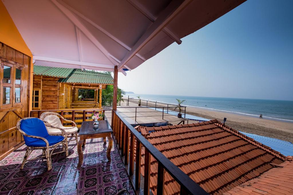 a house with a balcony with a view of the beach at Om Sai Beach Huts in Agonda