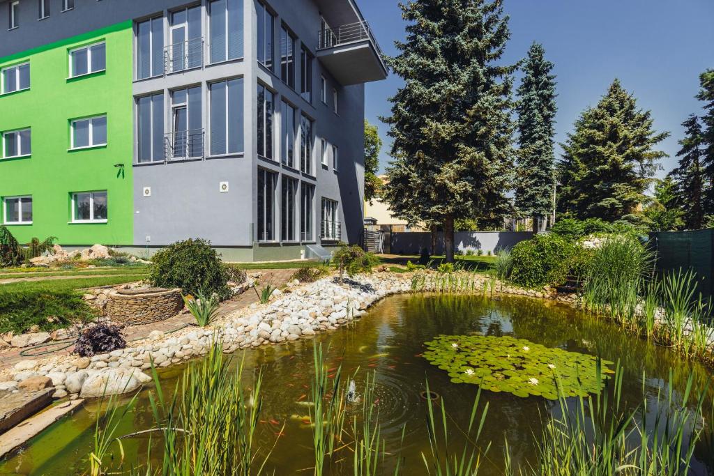 a house with a pond in front of a building at Panorama Apartments Presov in Prešov