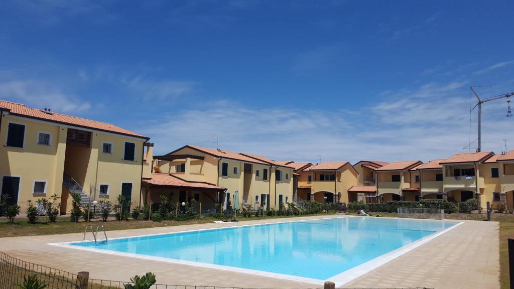 バデージにあるResidence con piscina Baia delle Mimoseの一部のアパートメントビルの前にスイミングプールがあります。