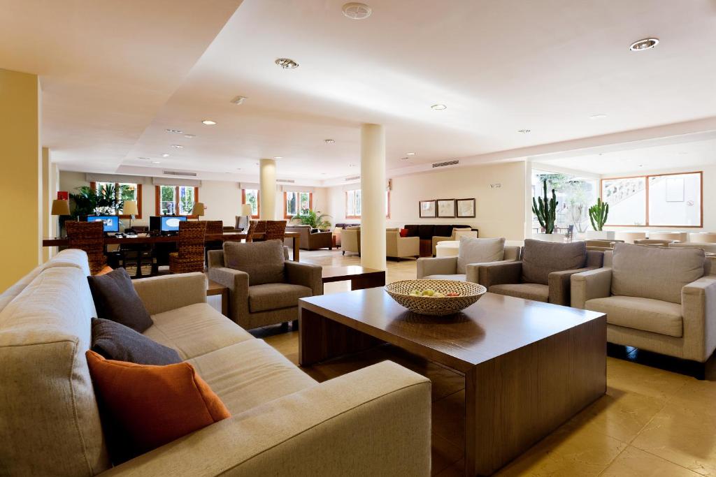 a living room with couches and a table at Minura Cala Galdana & Apartamentos d'Aljandar in Cala Galdana