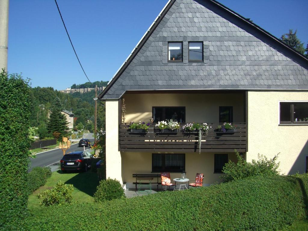 a house with a balcony with flowers on it at Gästehaus Jeremias in Königstein an der Elbe