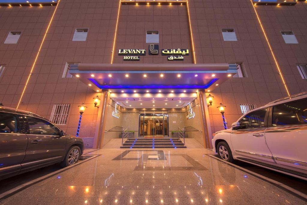 dos coches estacionados frente a un edificio en Levant Hotel en Najrán