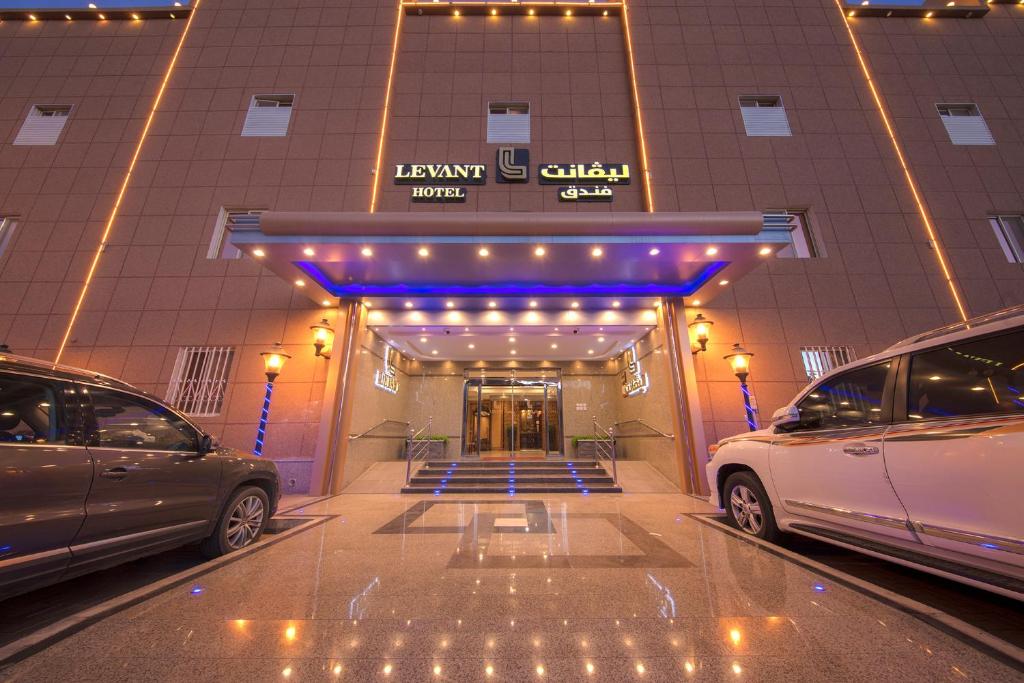 zwei vor einem Gebäude geparkt in der Unterkunft Levant Hotel in Najran