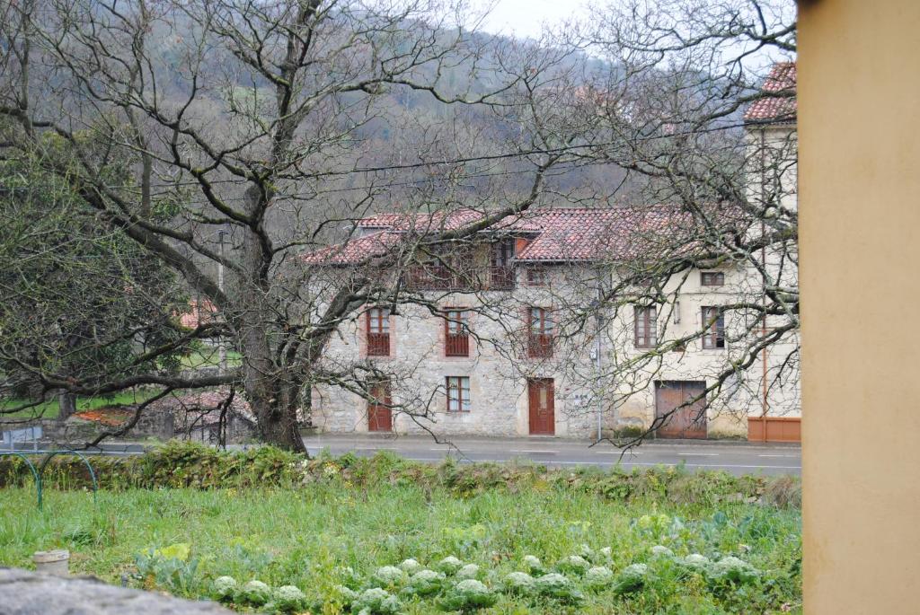 a large white building with a tree in front of it at Casa Rural La Roza 2 in Buelles