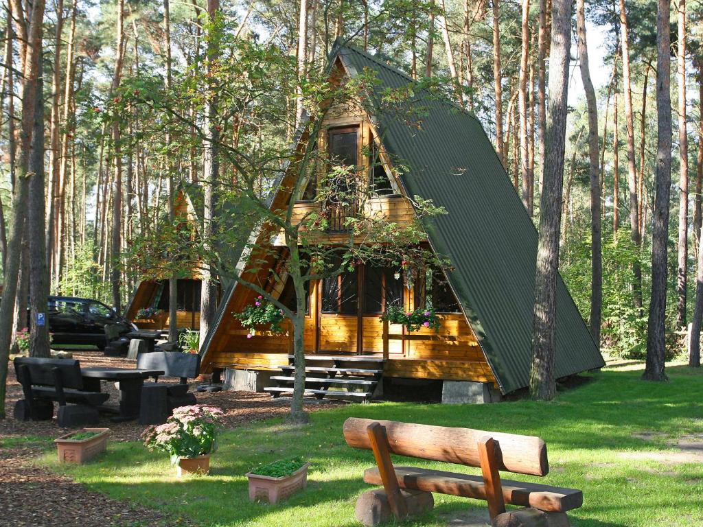 ein Baumhaus inmitten eines Parks mit einer Bank in der Unterkunft Chalet Nepumuk-1 by Interhome in Arendsee