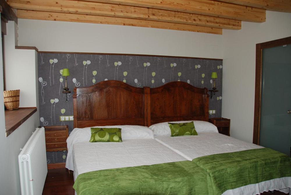 a bedroom with a large bed with green sheets at Hotel Rural El Balcón de Montija in Loma de Montija