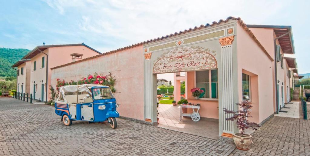 a blue cart parked in front of a building at Residence Corte Delle Rose in Garda