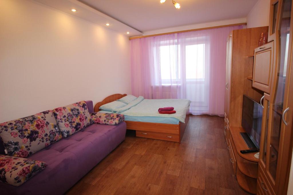 スィクティフカルにあるComfort apartment on Pervomayskaya 20のリビングルーム(紫色のソファ、窓付)