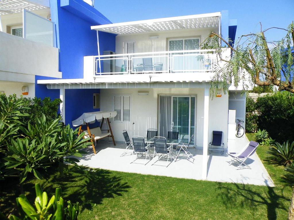 Casa azul y blanca con sillas y balcón en Case Vacanze Pomelia, en Marina di Ragusa