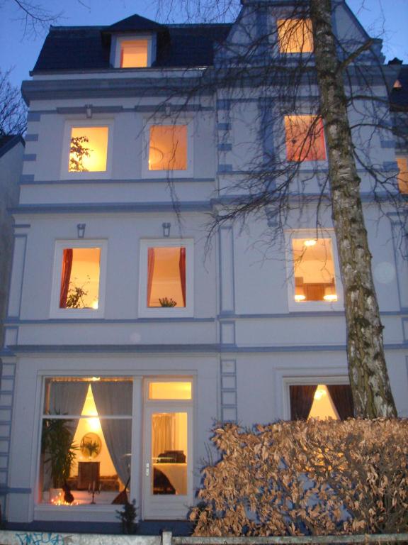 a white house with lights in the windows at Alster City Garden Villa in Hamburg