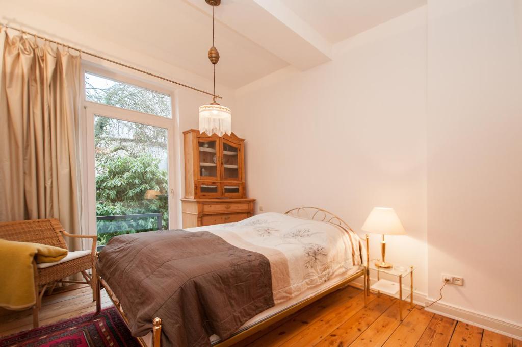 a bedroom with a bed and a window at Alster City Garden Villa in Hamburg