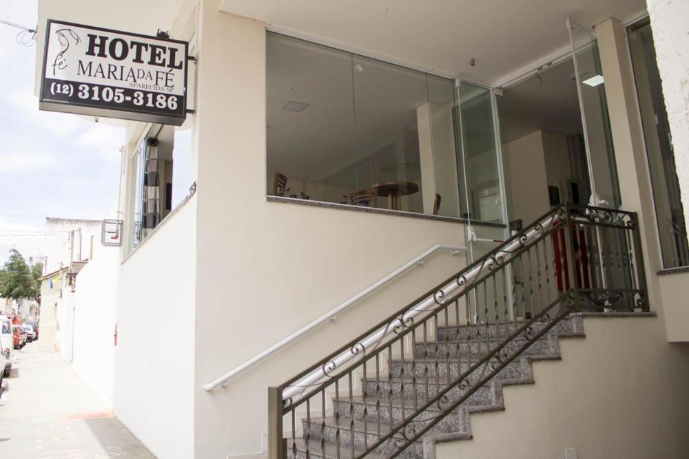 a hotel sign on the side of a building with stairs at Hotel Maria da Fé in Aparecida