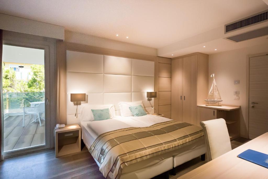 a bedroom with a large bed and a balcony at International Beach Hotel in Caorle