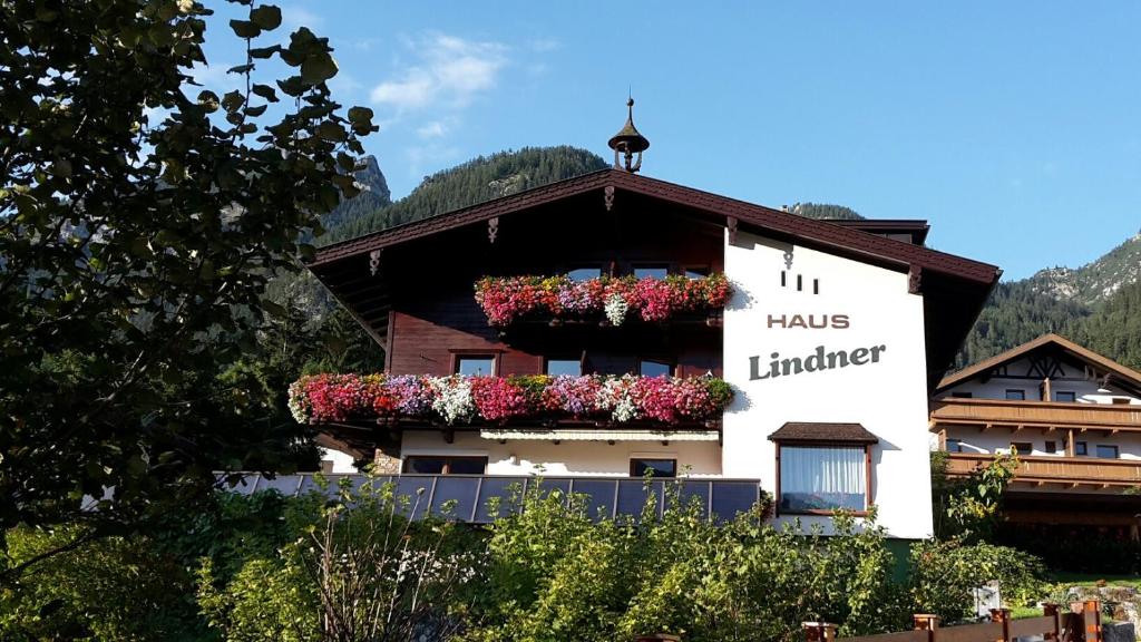un bâtiment avec des boîtes de fleurs sur son côté dans l'établissement Haus Lindner, à Maurach