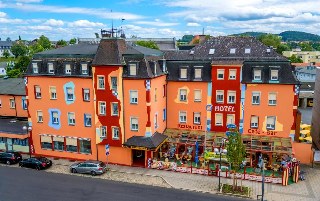 um grupo de edifícios cor-de-laranja numa cidade em Meister BÄR HOTEL Fichtelgebirge em Marktredwitz