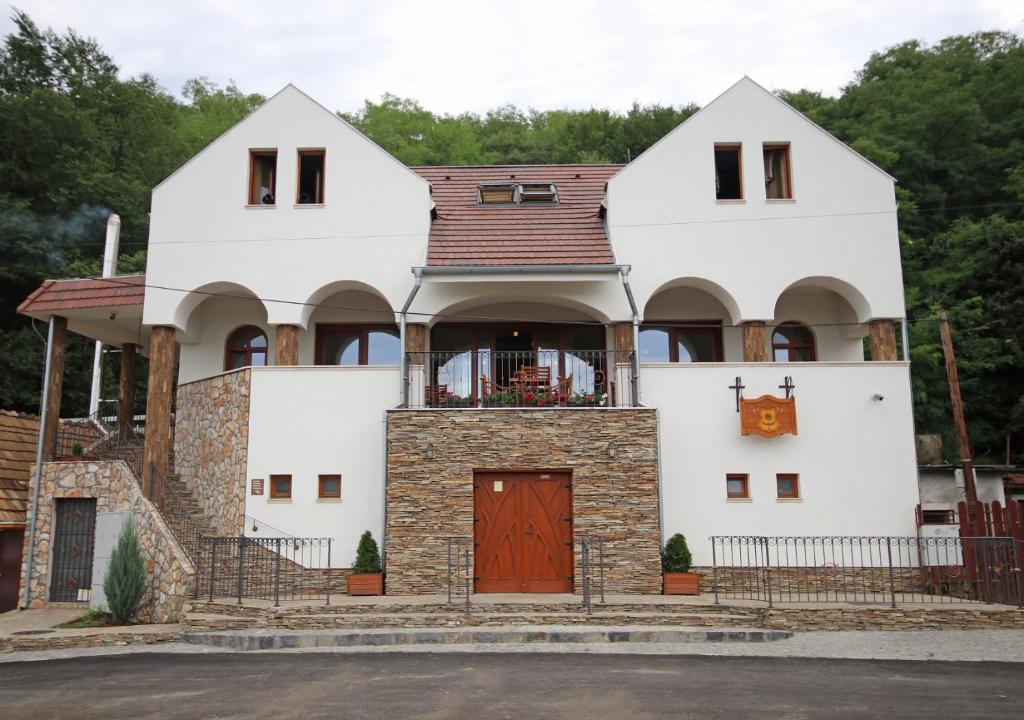una gran casa blanca con puerta roja en Penzión Kállai a Vináreň, en Fiľakovo