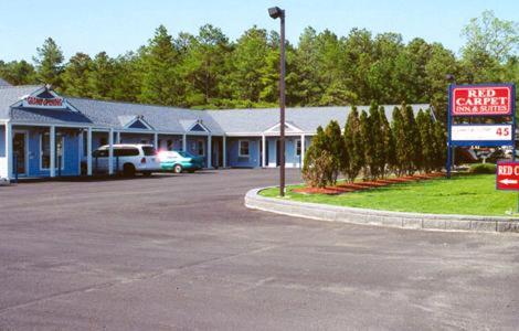 a parking lot in front of a building with a sign at Red Carpet Inn & Suites Hammonton - Atlantic City in Hammonton