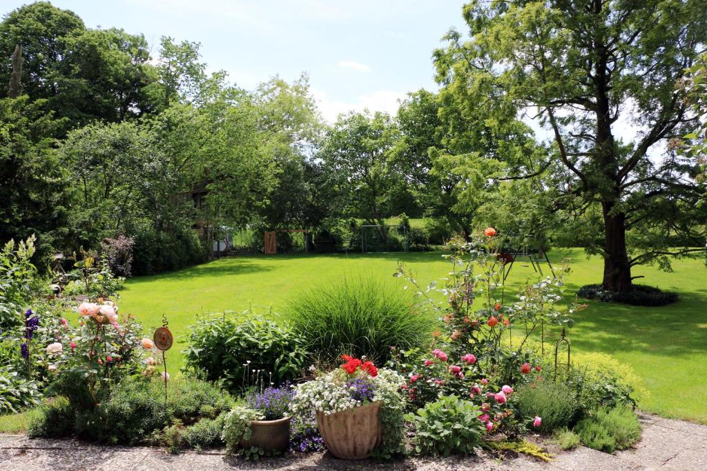 a garden with colorful flowers and a green yard at Hof Osterholz in Loit