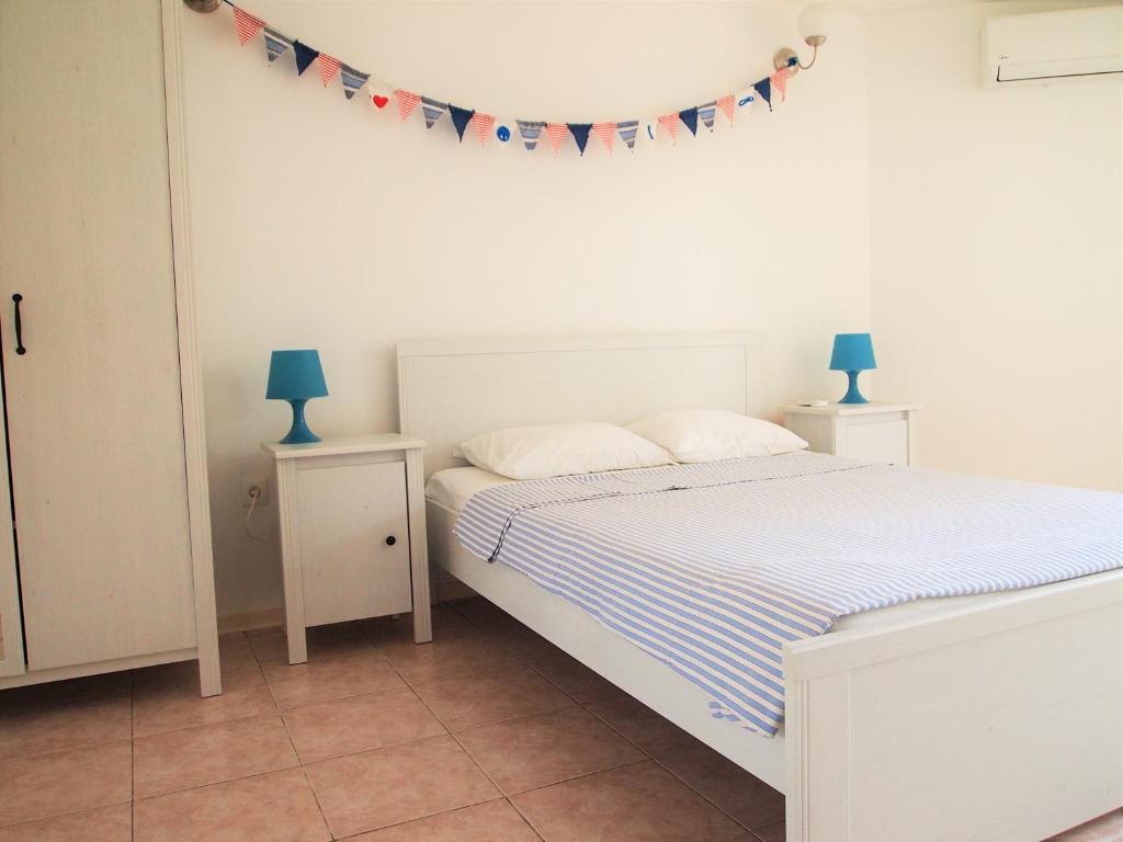 a bedroom with a bed and two tables with lamps at Studio Apartment Branko in Novalja