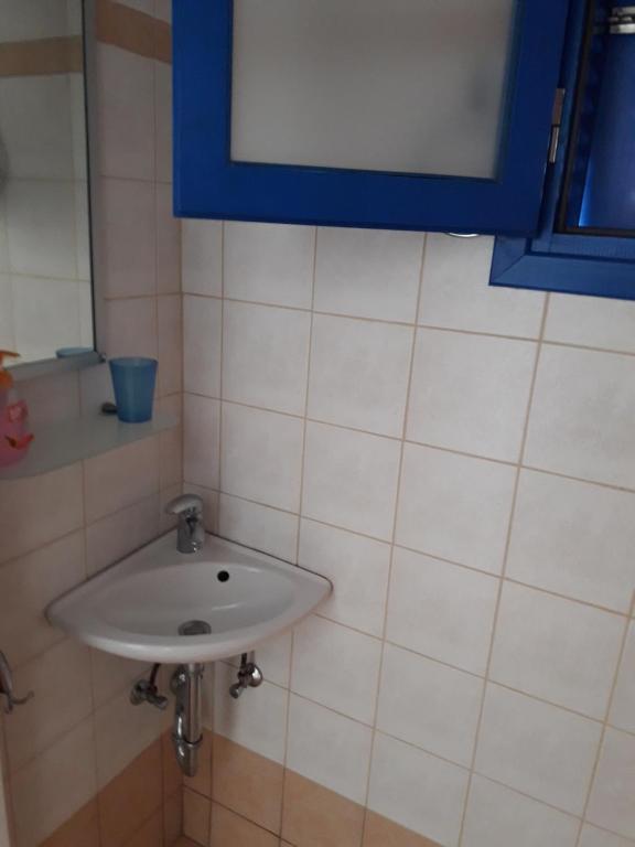 a white sink in a bathroom with a blue window at Vigles in Adamantas