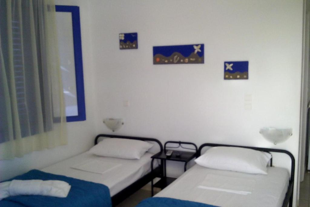 two beds in a room with pictures on the wall at Vigles in Adamantas