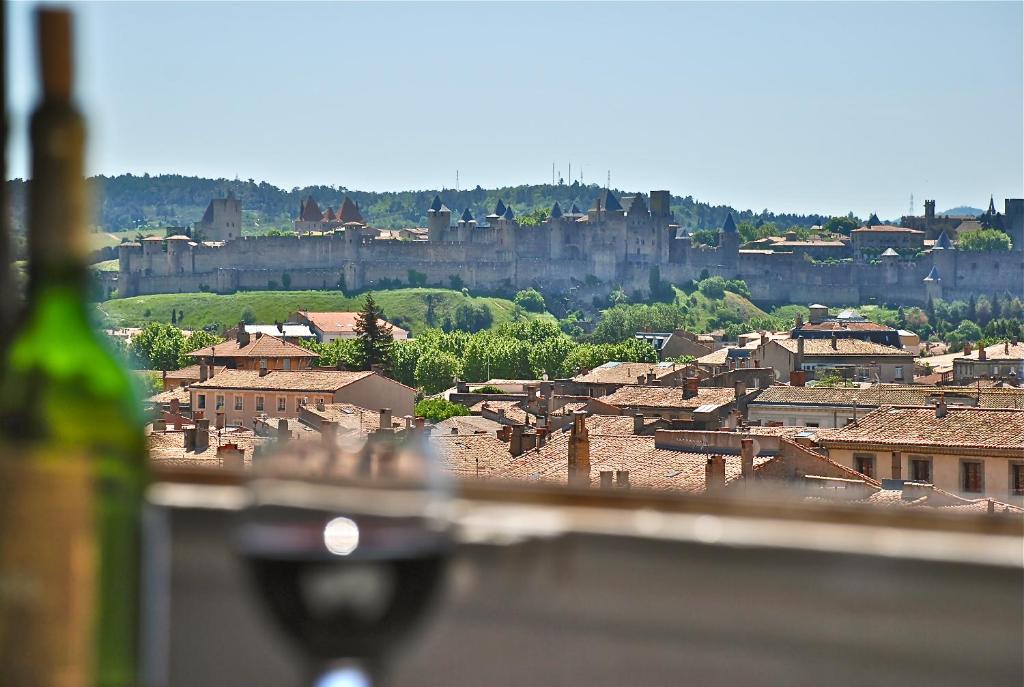 Blick auf eine Stadt mit einem Schloss im Hintergrund in der Unterkunft Mistral Apartment in Carcassonne