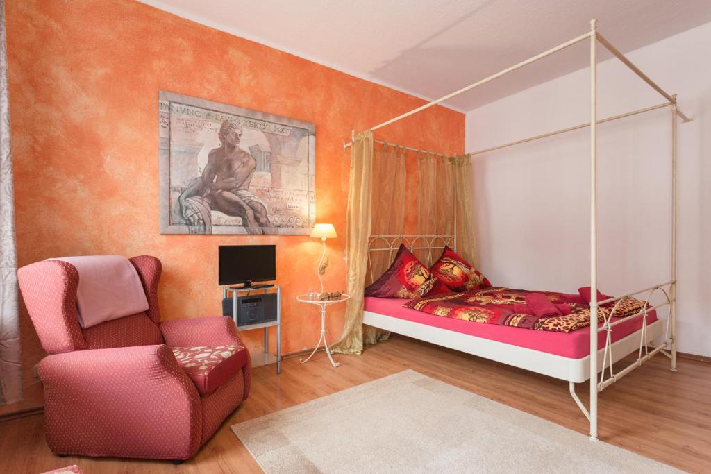 ein Schlafzimmer mit einem Himmelbett und einem Stuhl in der Unterkunft Ferienwohnung Residenz bis 6 Gäste , Ferienwohnung Dresden bis 4 Gäste, Ferienwohnung Elbflorenz bis 2 Gäste in Dresden