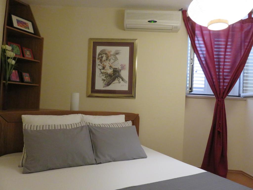 sypialnia z łóżkiem z czerwoną zasłoną w obiekcie Apartment Sunrise w Korčuli