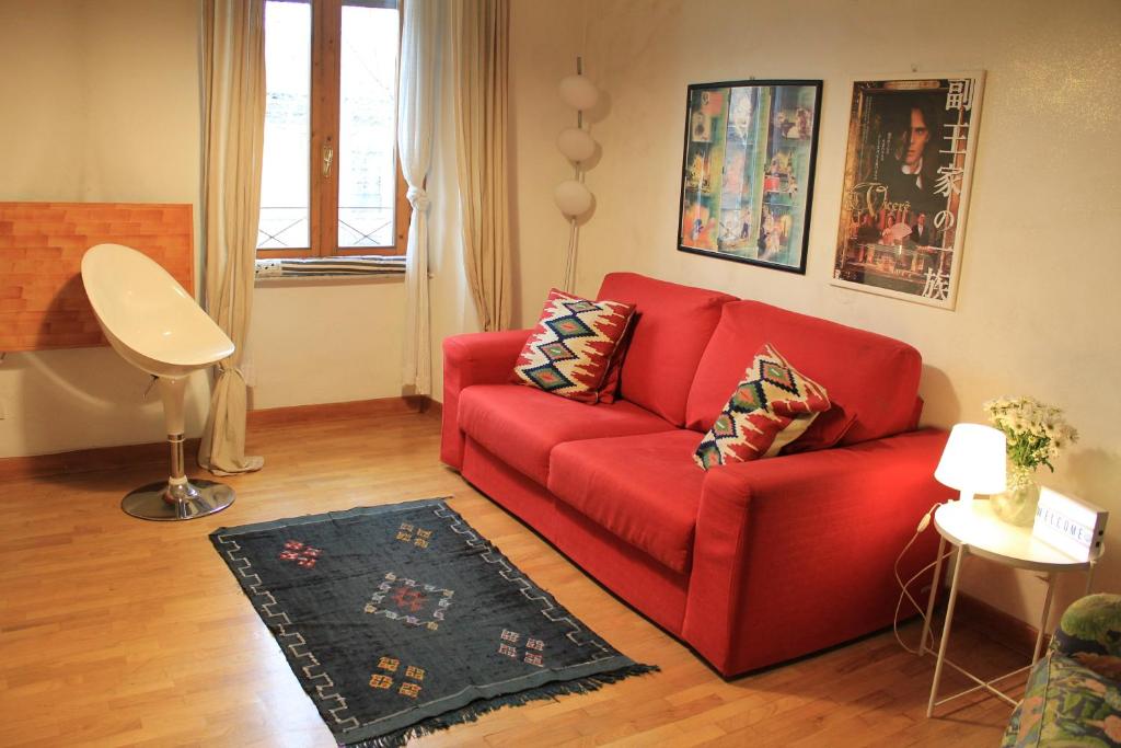 ローマにあるHello Vatican Apartmentのリビングルーム(赤いソファ、ラグ付)