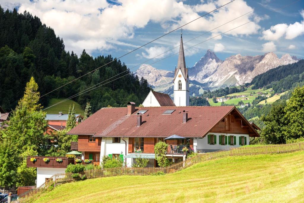 eine Kirche auf einem Hügel neben einem Feld in der Unterkunft Hotel-Pension Faneskla in Silbertal