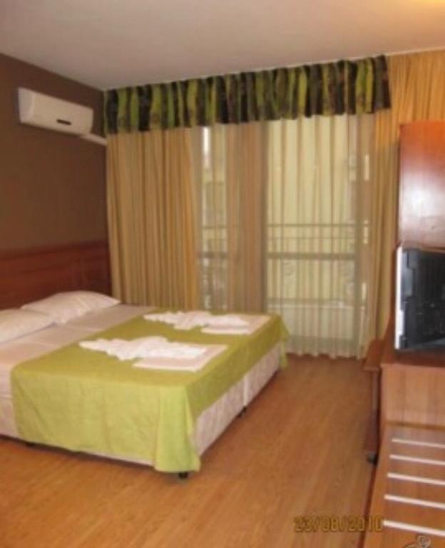 a hotel room with a bed and a television at Hotel AVALON in Nesebar