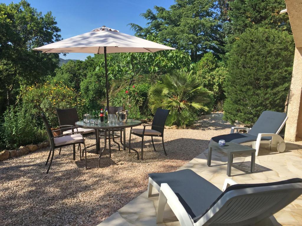 un patio con mesa, sillas y sombrilla en Apartment Les Collines de valescure by Interhome, en Saint-Raphaël