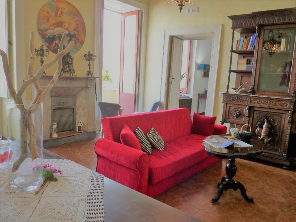 a living room with a red couch and a fireplace at Dimora del Conte Sorrento coast seaview in Vico Equense