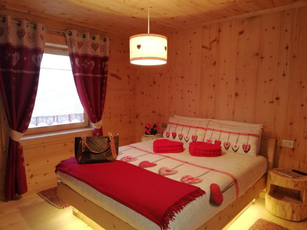 - une chambre avec un lit dans une cabane en rondins dans l'établissement Al Bait Del Legn, à Bormio