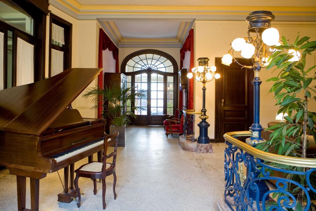 - un salon avec un piano et un vase bleu dans l'établissement Charme Hotel Hancelot, à Gand